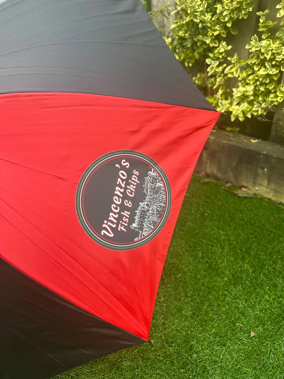 Close-up of the original Vincenzo's Fish and Chips logo printed on the red umbrella panel